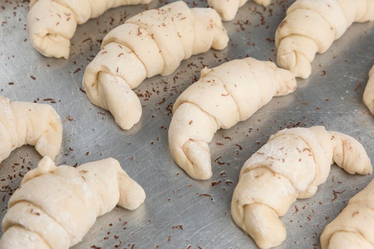 Croissants crudos enrollados en los que se aprecian las capas de masa laminada